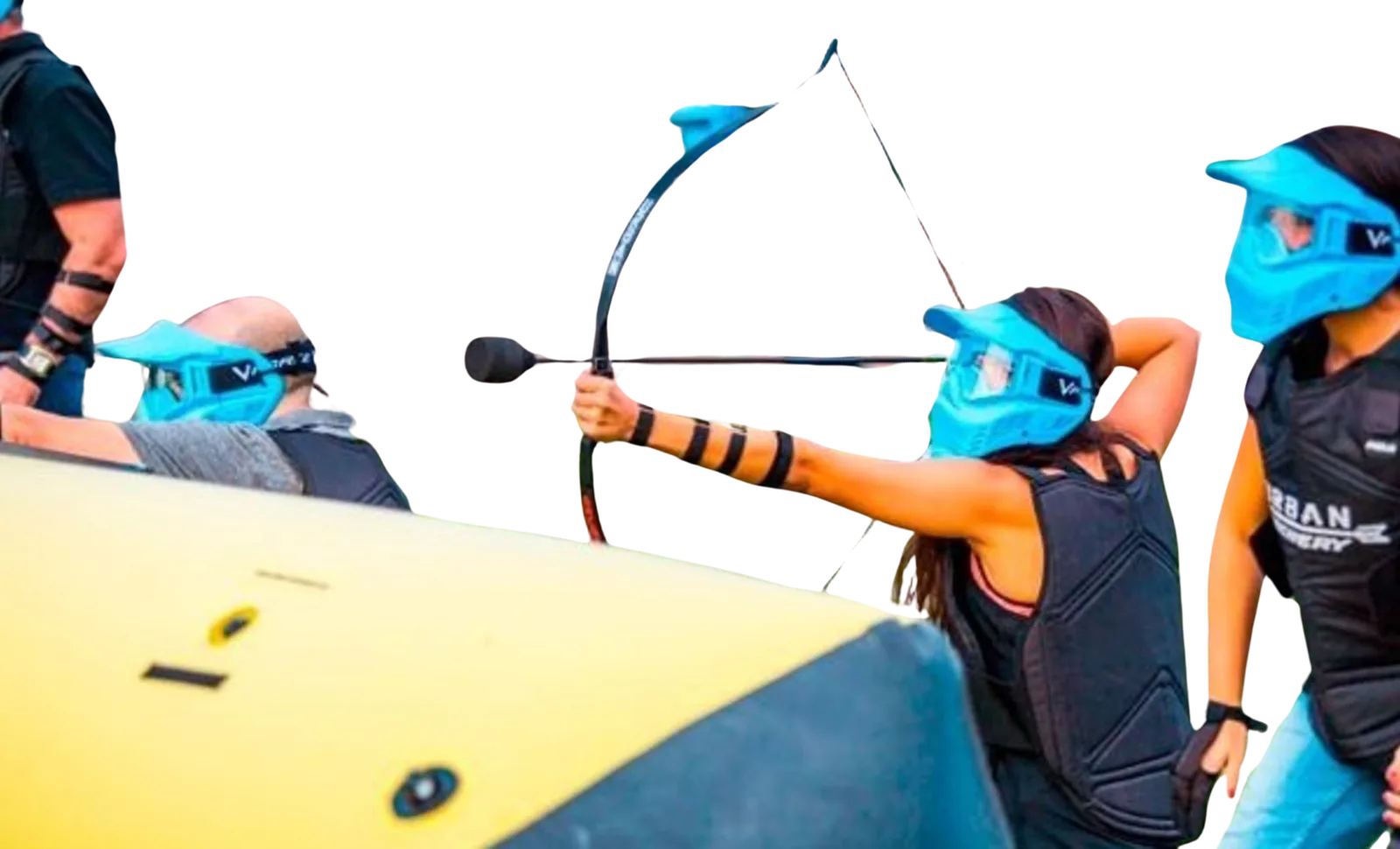 Joueuse d'archery tag qui tire à l'arc derrière un bunker gonflable