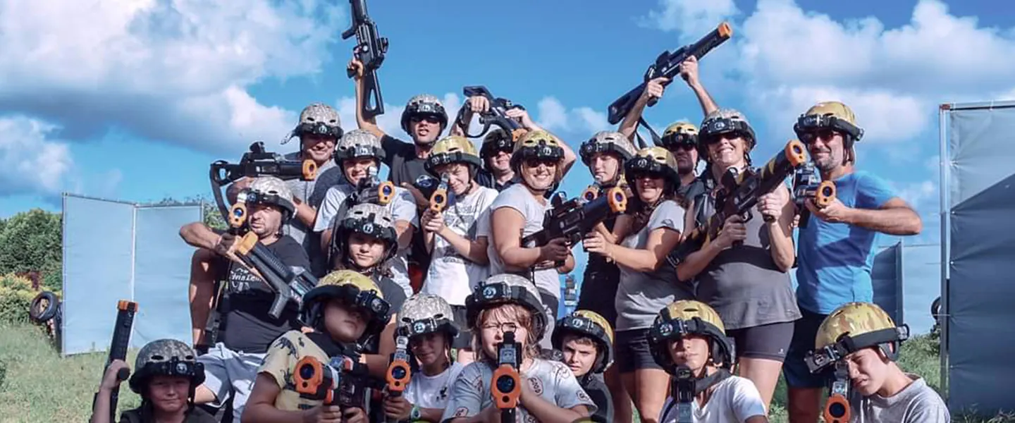 Groupe d'adultes en tenue de laser game qui pose avec les lanceurs