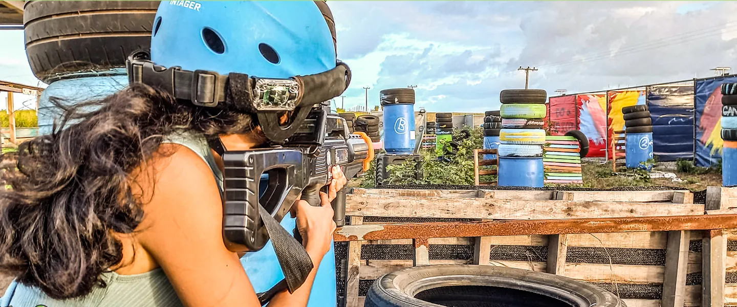 Jeune joueuse de laser game qui vise en extérieur